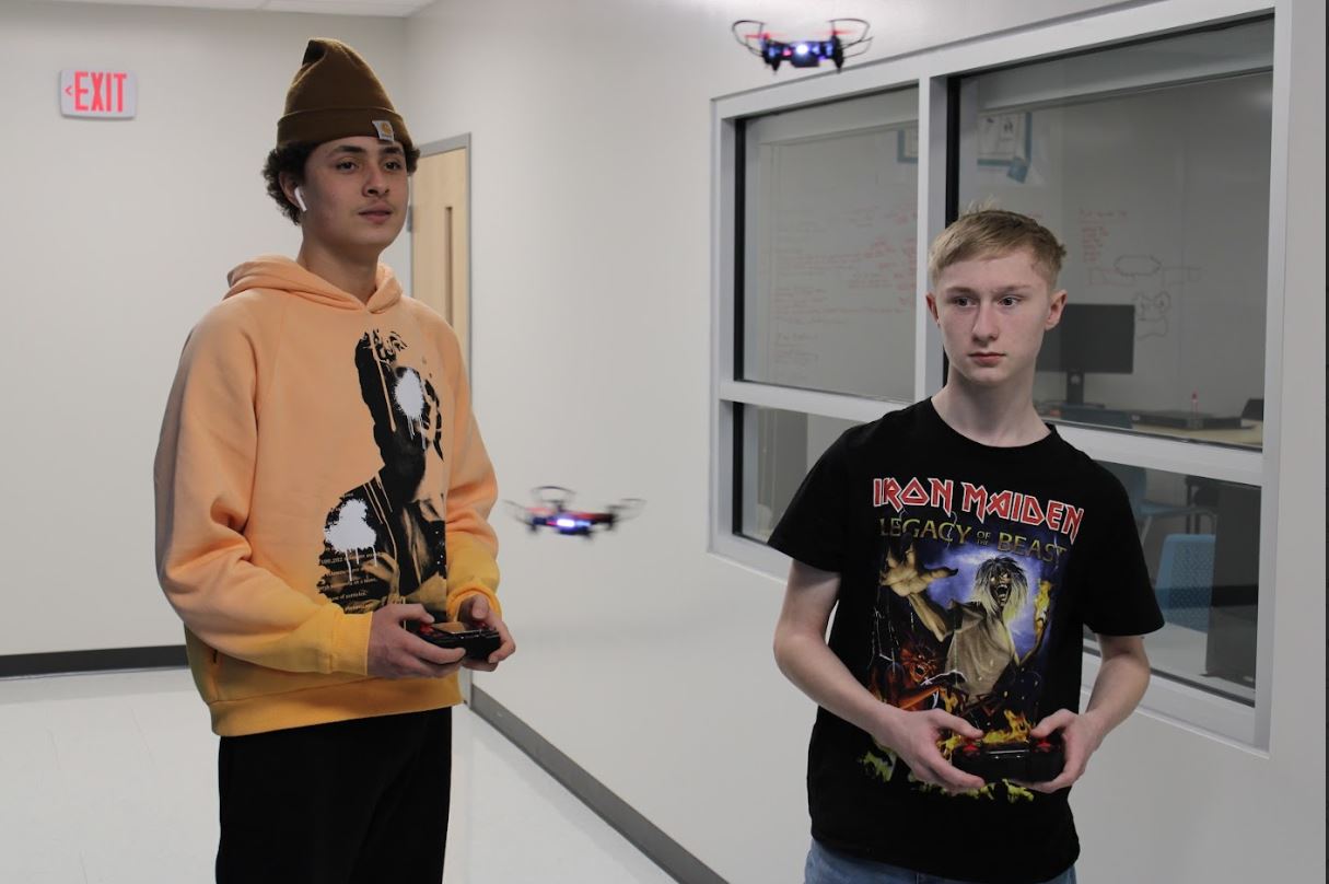 An image of students Kye - on the left - and Zach - on the right- flying drones